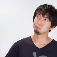 眉間にしわを寄せて不満そうにしかめっ面をする男性の写真