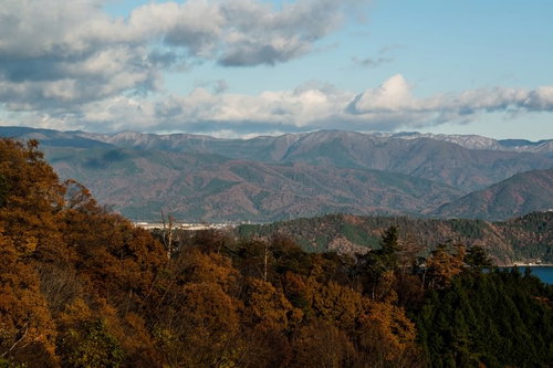 遠くまで連なる山々が茶色く色づく秋の山岳風景