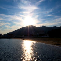 水平線に太陽が沈みオレンジに染まる須磨海岸の夕日の写真