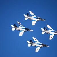 青空を縦に並んで飛ぶブルーインパルス（T-4）の写真