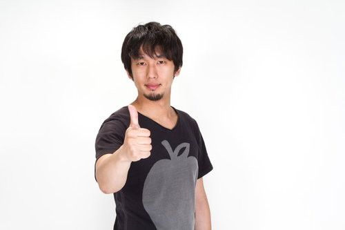 親指を立ててグッジョブ！する黒Tシャツの男性