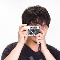 片目をつぶってカメラを構える「見逃さない！」の男性の写真