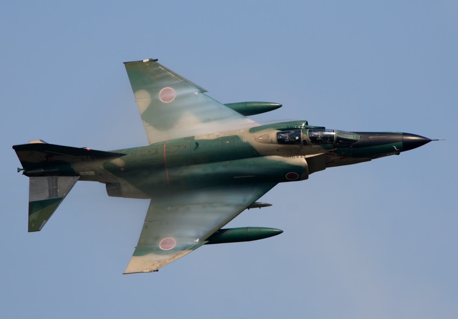 青空を飛ぶ迷彩塗装のRF-4偵察機