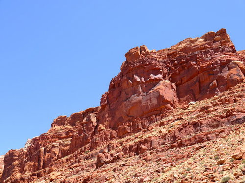 青空の下で見上げるモニュメントバレーの岩山