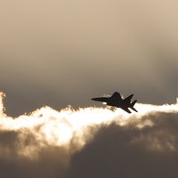 夕焼けの雲を突き進むF-15の光の河（新田原基地）の写真