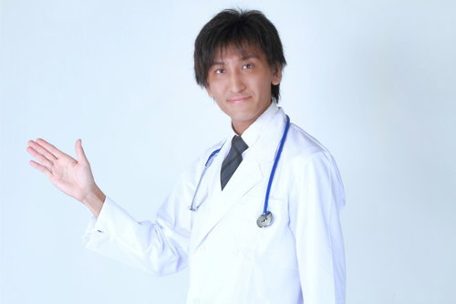 手を前に出して案内するポーズの白衣のドクター