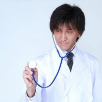 患者の胸に聴診器を当てて診察する医師の写真