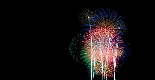 夜空を複数の花火が同時に照らす花火大会の風景
