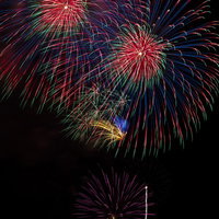 暗い夜空にぱっと開く色彩豊かな打ち上げ花火の写真