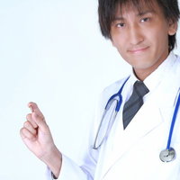 手のひらにカプセル薬を載せた白衣の医師の写真