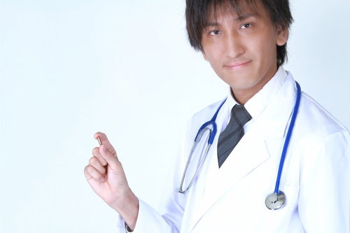 手のひらにカプセル薬を載せた白衣の医師
