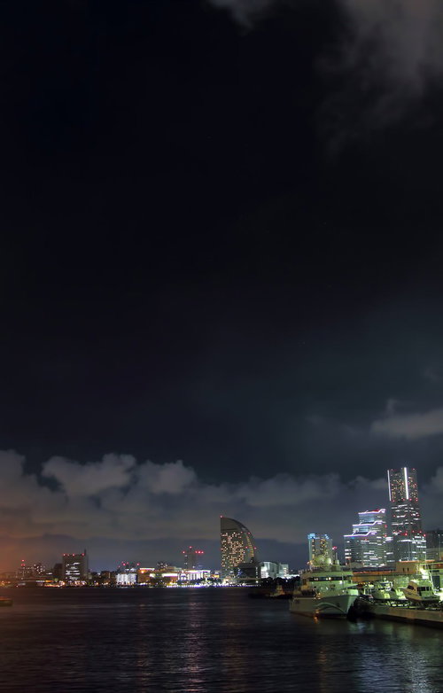 高層ビルの光が水面に映り込むみなとみらいの夜景