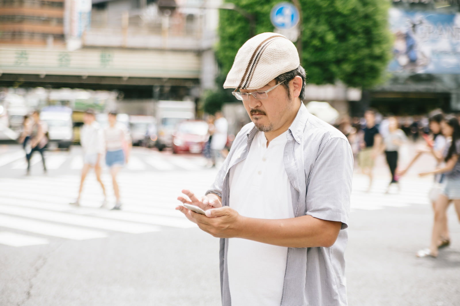 横断歩道でスマートフォンを操作しながら歩く男性［モデル：ナリシゲ］