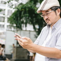 キジトラ猫の顎をなでる手の写真