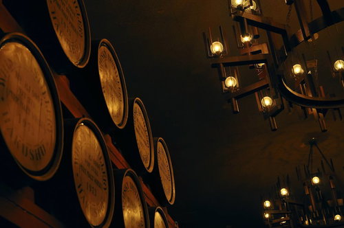 積み重なったウイスキーの木樽と照明