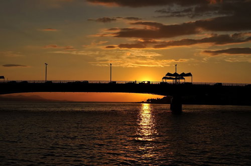 夕暮れ後の薄暗い空と静かな波が打ち寄せる浜辺