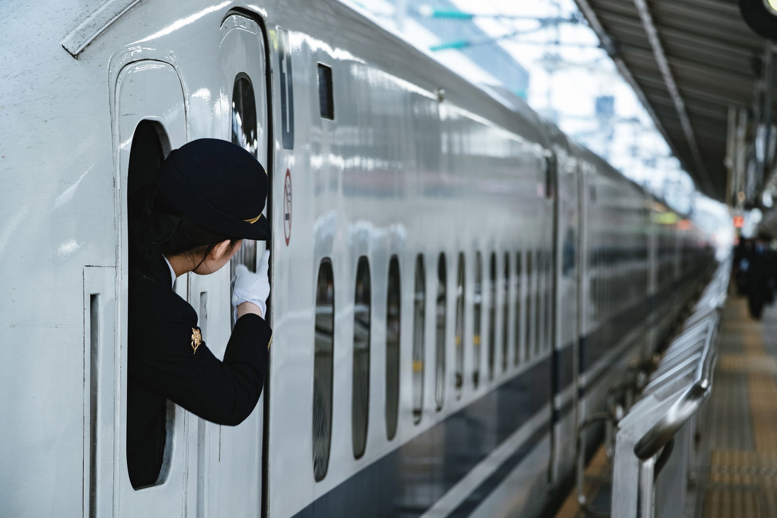 ホームで停車中の電車で指差し確認による安全確認を行う車掌