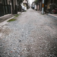 住宅街の路地裏にある砂利道と民家の街並みの写真