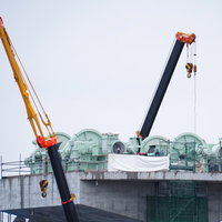 復興作業中の気仙川水門とクレーン車の工事現場の写真