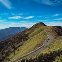 UFOラインと秋空に浮かぶ山岳の稜線を走る景観道路の写真