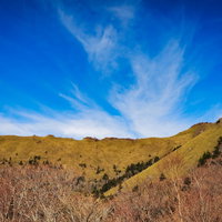 紅葉に染まる山並みと秋空の風景の写真