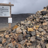 阿蘇山の火山地帯に積まれた岩石と立ち入り禁止の看板の写真