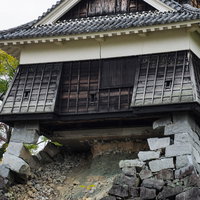 熊本城の崩れ落ちた石垣と崩れない戌亥櫓（いぬいやぐら）の写真