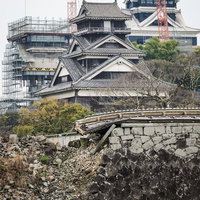 復興工事中の熊本城と地震で崩れた石垣、工事用クレーンと天守閣の写真