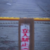 崩壊した道路に設置された立入禁止の札と危険区域の写真