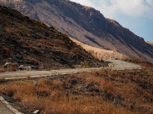 阿蘇山の荒れ果てた山へと続く道路と険しい岩肌