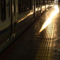 JR大阪駅のホームに停車する車両と夕暮れに染まる線路の写真