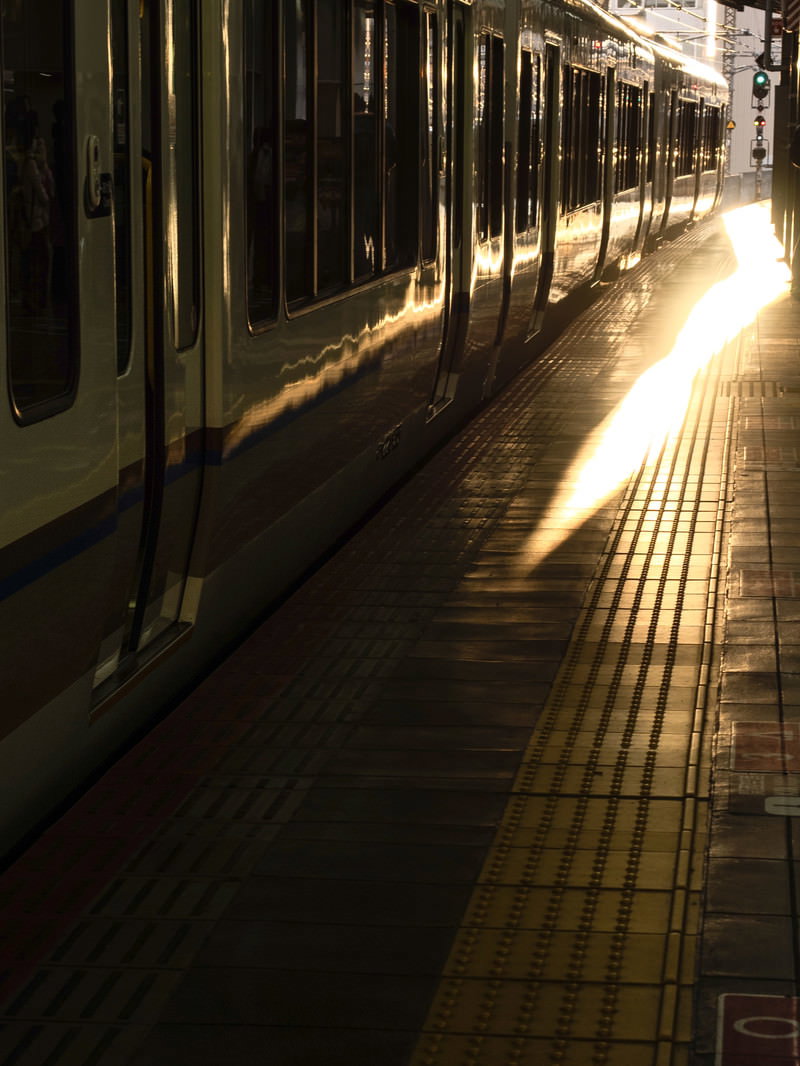JR大阪駅のホームで夕暮れの光に照らされる停車中の電車