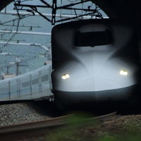 トンネルを抜けて明るさへ向かう新幹線の高速走行の写真
