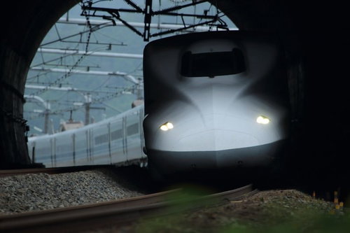 トンネルを抜けて明るさへ向かう新幹線の高速走行