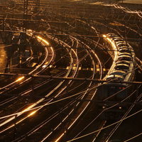 地方の小さな駅でスマホを見る女性の写真