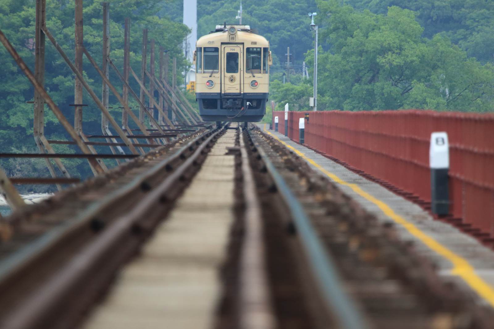 鉄橋を走る京都丹後鉄道のクリーム色の電車