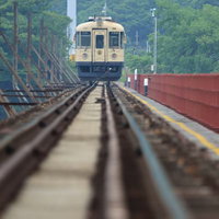 京都丹後鉄道の線路を走るクリーム色と紺色の電車の写真