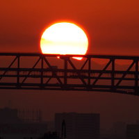 大阪港の陸橋と朝日のシルエット - 夜明けの産業風景の写真