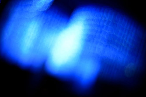 ぼけた青白い光が浮かぶ夜の抽象写真