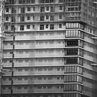 建設中の高層マンションと複数の白いクレーン機の工事現場の写真