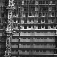 建設用クレーンを備えた高層ビルの足場工事の写真