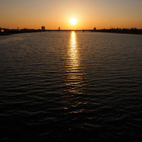 河川沿いの街並みを照らす夕焼けのエンジェルロードの写真