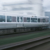 高速走行中のJR電車の白い車体と青いラインの写真