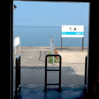 下灘駅のホームに立つ駅名標と四国の海景色の写真