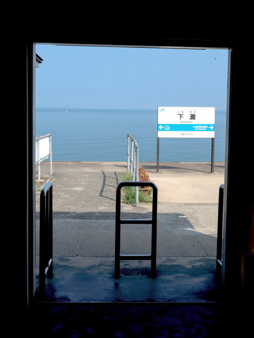 下灘駅のホームに立つ駅名標と四国の海景色
