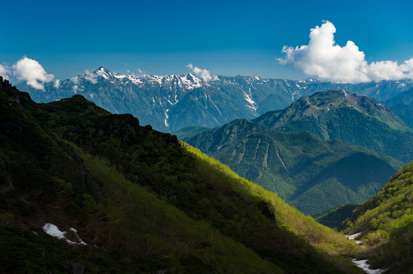 青空の下、北アルプスの山々を背景にした乗鞍新登山道の稜線