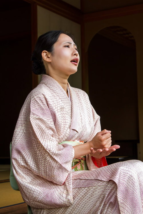 顎に手を当ててアイデアを練り考え込む女将さんの表情