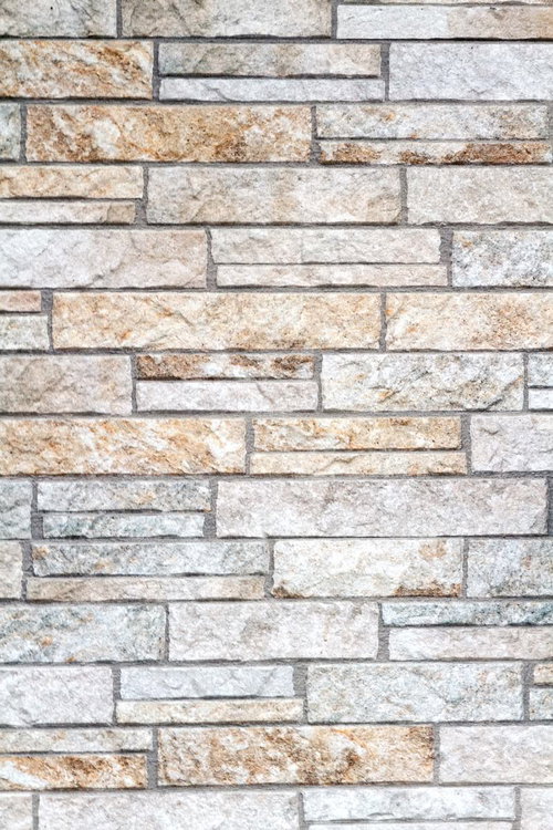 凸凹のごつごつした表面の石タイルの壁のテクスチャ