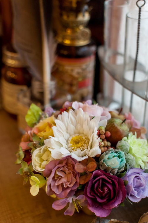 赤やピンクの造花をバランスよくまとめたフラワーアレンジメント