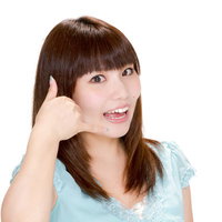 笑顔でスマホを手に「電話してね！」とポーズする女性の写真